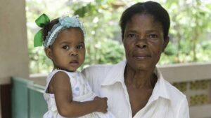 A woman holds a small child in her arms. 