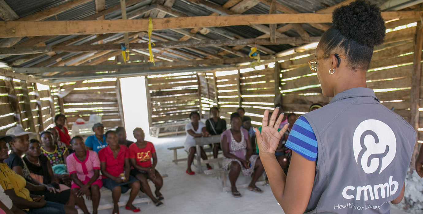A CMMB staff members speaks to community members in Haiti.